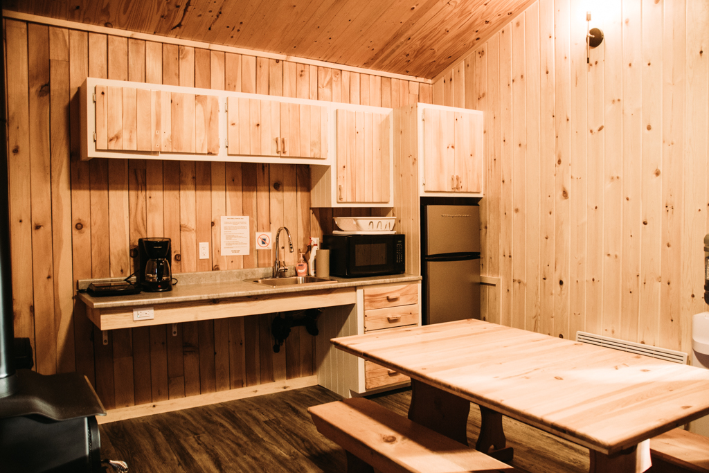 Interieur d'un chalet en bois avec un comptoir adapté à des personnes en fauteuil